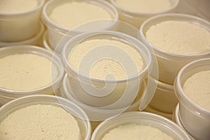 Moulds with pressed cheese at factory, closeup