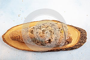 Mouldy moldy bread. Mould growing old bread on wooden table. Wastage of bread and stale bread