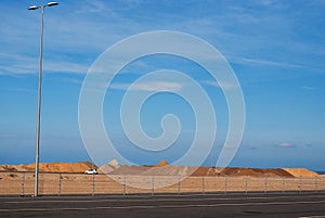 A mound of red sand on a blue sky background