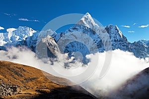 Mount Ama Dablam within clouds and blue sky
