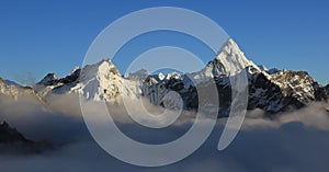 Mount Ama Dablam and other mountains reaching out of a sea of fog