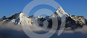 Mount Ama Dablam and other snow covered mountains reaching out of a sea of fog