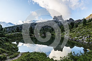 Mount Averau reflected in lake Limedes at sunrise, blue sky with clouds, Dolomites, Veneto, Italy