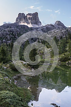 Mount Averau reflected in lake Limedes at sunrise, blue sky with clouds, Dolomites, Veneto, Italy