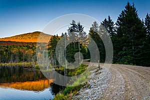 Mount Deception reflecting in a pond along a dirt road in White