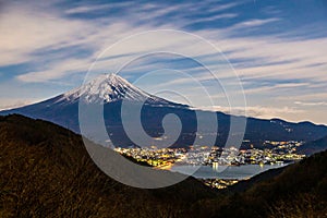 Mount Fuji, or Fuji San in Japanese, famous mountain in Japan standing tall against cloudy blue sky at night towering the
