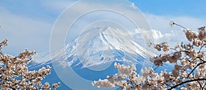 Mount Fuji with snow capped, blue sky and beautiful Cherry Blossom or pink Sakura flower tree in Spring Season at Lake kawaguchiko