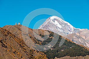 Mount Kazbek Mkinvartsveri and Gergeti church at sunny day. Caucasus mountains