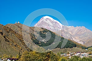 Mount Kazbek Mkinvartsveri and Gergeti church at sunny day. Caucasus mountains