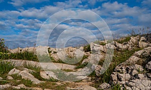 Mount with many rocks under a blue cloudy sky