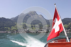 Mount Pilatus with Swiss Flag and wake of boat.