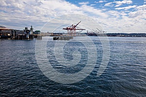 Mount Rainier and Seattle Logistics shipping terminals waterway. View from Elliott Bay during summer.