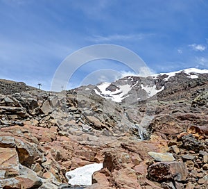 Mount Ruapehu landscape and small watefall flowing under a snow cap in Tongariro National park