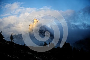 Mount Sass de Stria at sunrise, blue sky with clouds and fog, Falzarego pass, Dolomites, Veneto, Italy photo