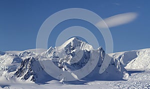 Mount Shackleton and clouds above it in a blue bright sky on the