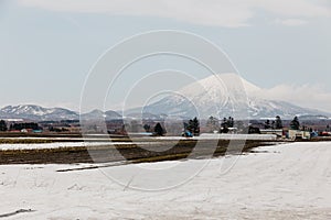 Mount Yotei inactive stratovolcano with village and snow cover on the ground in winter in Hokkaido, Japan