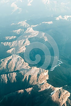 Mountain aerial from airplane with sunlight at sunset