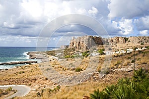 Mountain with an ancient tower overlooking the ocean Cala Macari Sicily, Italy