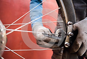 Mountain bicycle repairing. Mechanic at work fixing bike spokes