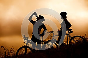 Mountain bike couple drinking in silhouette