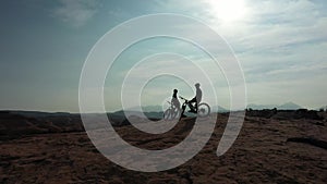 Mountain bike, extreme sports and silhouette or people relax during outdoor ride, desert journey or off road cycling