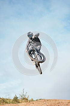 Mountain, bike jump and person cycling on bicycle for extreme sports competition stunt or training in nature. Skill