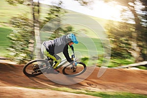 Mountain bike, man and motion blur in forest for competition, speed or off road adventure on path. Fast athlete, sports