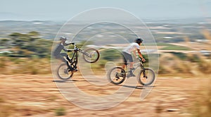 Mountain bike, men and race with speed, dirt and nature in summer with wheelie, extreme sport and motion blur. Friends
