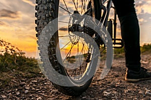 Mountain bike rear wheel detail. Back shot of mountain bike on sunset. Mountain bike tire.