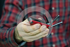 mountain bike repair. Bike mechanic in the workshop. Mechanic holds the multi tool for bicycle repair. Multitool in a hand close-