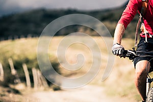 Mountain bike rider on country road, track trail in inspirational landscape