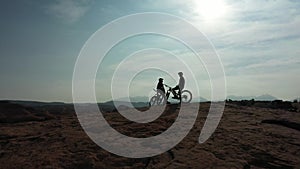 Mountain bike, silhouette and sports people relax during outdoor ride, desert journey or off road cycling. Sky