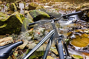 Mountain bike standing on a forest river stream