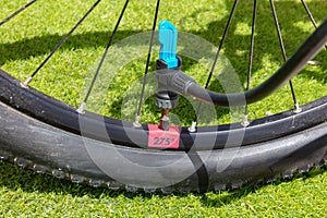 A mountain bike tire with the tube of an air pump in close-up.