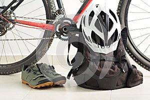 Mountain bike, velo shoes, backpack and white helmet.