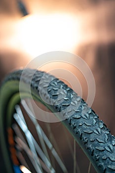 Mountain bike wheel tire protector. Bicycle tire close-up against the background of beautiful yellow lighting. Bicycle repair