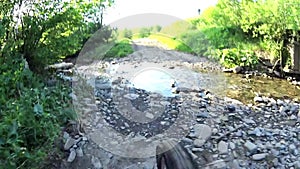 Mountain biker crossing river on sunny day, Bieszczady Mountains, Poland