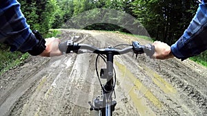 Mountain biker cycling through muddy dirt road in Bieszczady, Poland