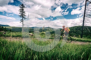 Mountain biker cycling riding in woods and mountains