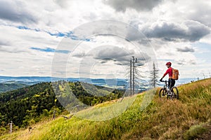 Mountain biker cycling riding in woods and mountains