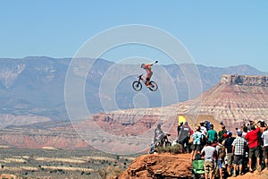 Mountain biker jumps cliff and crowd watches