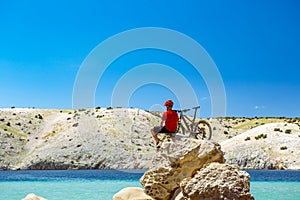 Mountain biker looking at mountains and beach