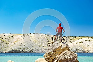 Mountain biker looking at mountains and beach