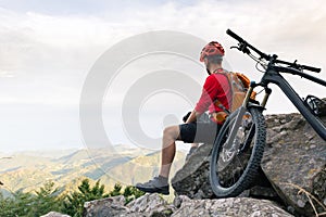 Mountain biker looking at view on bike trail in autumn mountains