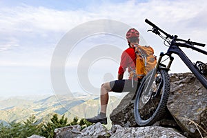 Mountain biker looking at view on bike trail in autumn mountains