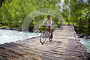 Mountain biker on old wooden bridge
