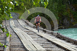 Mountain biker on old wooden bridge