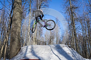 Mountain biker rider does a dirt jumping trick in the winter. Moto whip on bike