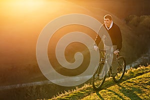 Mountain biker riding on bike in spring inspirational mountains landscape. inspiration outdoors in sunset.