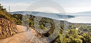 Mountain biker riding on bike in summer sunset woods